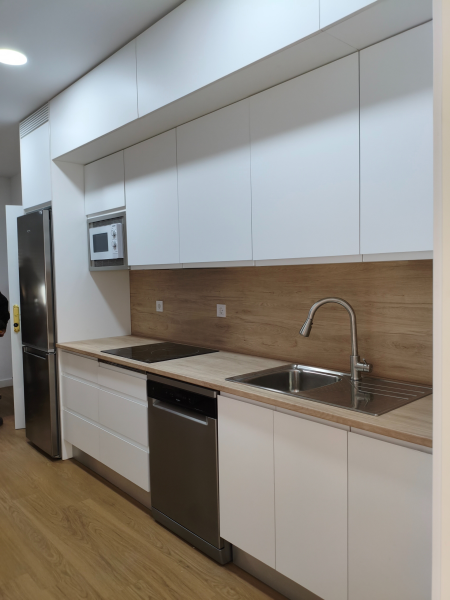 Cocina blanca mate a medida en Madrid con encimera de formica en tono madera