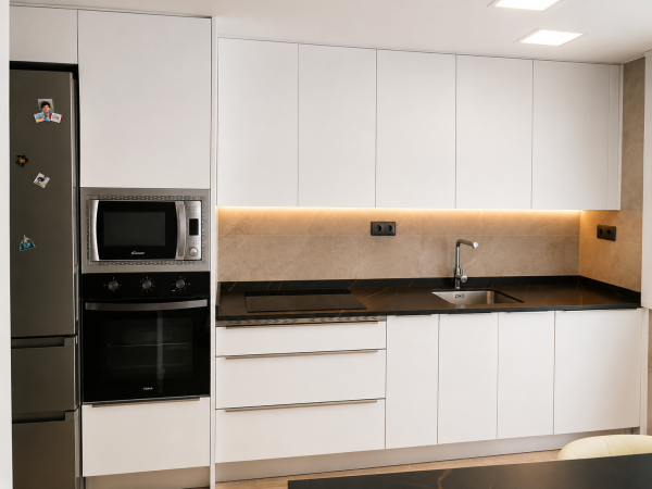 Detalle de cocina con encimera negra y revestimiento claro